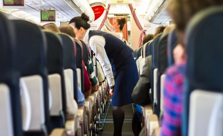 Flugbegleiterin hilft Passagierin