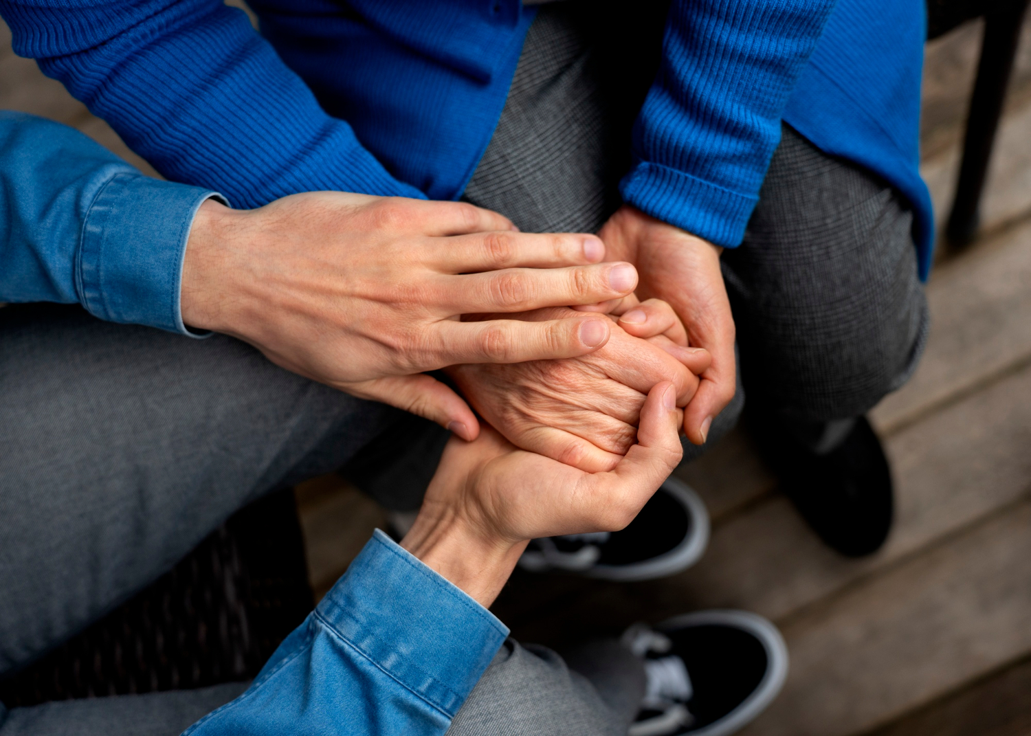 Nahaufnahme einer Hand, die die einer älteren Person hält